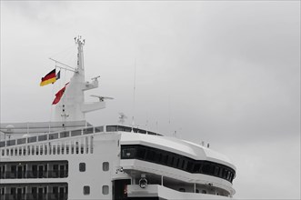 German flag flying on the bridge of a white cruise ship, Queen Mary 2, Hamburg, Hanseatic City of