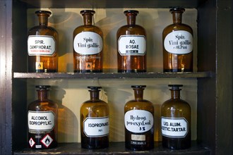 Glass jars with ingredients for medicines stand on a shelf in the historic Berg-Apotheke pharmacy