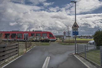Suburban railway crossing an ungated level crossing in a village, Forth, Middle Franconia, Bavaria,