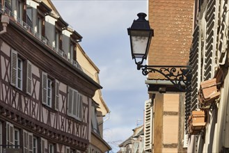 Lantern on a house and facade of a half-timbered house in the old town centre of Colmar, Department