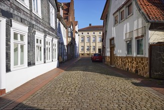 Papenmarkt cobblestone alley, a slate-panelled house and the Hansehaus in the old town of Minden,