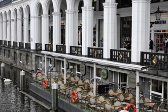 A cafe with an outdoor terrace next to a body of water in an urban area, Hamburg, Hanseatic City of