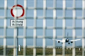 A Lufthansa aircraft lands at Frankfurt Airport, warning sign with the inscription Achtung