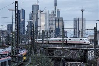 An ICE train crosses a bridge at Frankfurt Central Station, the Frankfurt skyline with skyscrapers