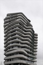 Marco Polo Tower, A unique wave-shaped modern building under a cloudy sky, Hamburg, Hanseatic City