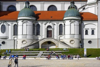 Spring awakening, people sunbathing in front of the Lorenzkirche, Kempten, Allgaeu, Bavaria,