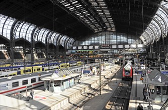 Spacious station concourse with trains, tracks and a few people, Hamburg, Hanseatic City of
