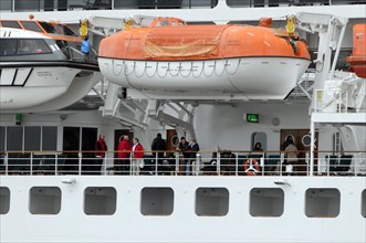 Passengers stand next to lifeboats on board the Queen Mary 2, Hamburg, Hanseatic City of Hamburg,