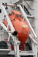 Red lifeboat suspended from a white ship in the harbour, Hamburg, Hanseatic City of Hamburg,