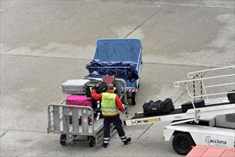 Airport employee operating a luggage trolley on the tarmac, Hamburg, Hanseatic City of Hamburg,