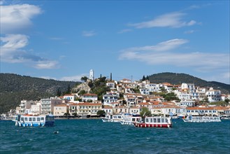 View of a picturesque harbour with colourful houses and boats against a blue sky with clouds, view