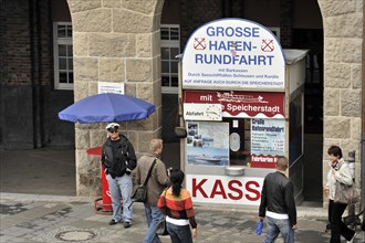 People standing in front of a kiosk for harbour tours in an urban environment, Hamburg, Hanseatic
