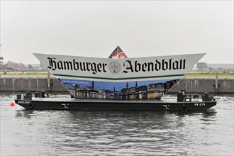 Ship with a large advertising banner of the Hamburger Abendblatt on a river, Hamburg, Hanseatic