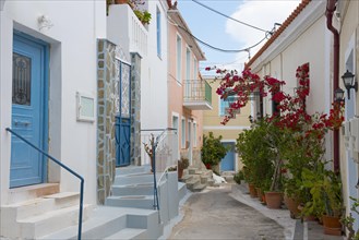 Quiet street with white houses, blue doors and potted plants on a stone staircase, Poros, Poros