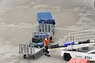 Ground staff loading luggage onto the conveyor belt of an aircraft, Hamburg, Hanseatic City of