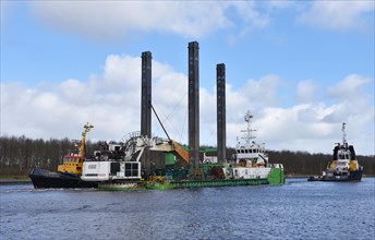 Tugboat, tugboat pulling dredger Peter The Great in the Kiel Canal, Kiel Canal, Schleswig-Holstein,