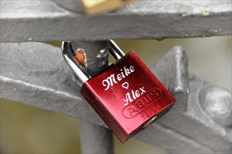 A red love lock with engraved names attached to a metal railing, Hamburg, Hanseatic City of
