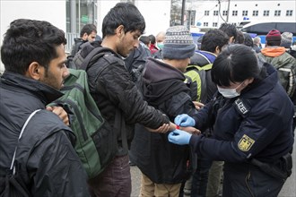 After arriving at Rosenheim station, refugees are given wristbands by federal police officers for
