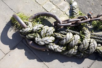 Old rusty iron ship mooring ring and ropes on a quayside at Ipswich Wet Dock, England, UK