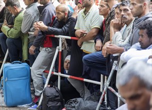Refugees from Syria wait behind barriers in the central reception centre for asylum seekers at the