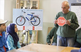 Syrian refugees learn traffic rules during an integration course. An employee of the