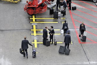 Crew members with wheeled suitcases walking down an aeroplane staircase, Hamburg, Hanseatic City of