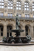 Historic fountain with sculpture in front of a detailed decorated building, Hamburg, Hanseatic City