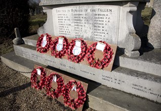 Remembrance poppy wreaths on village war memorial, Snape, Suffolk, England, United Kingdom, Europe