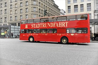 A red sightseeing double-decker bus travelling on a city street, Hamburg, Hanseatic City of