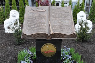 Garden statue of an open book with lion figures and a memorial emblem below, Hamburg, Hanseatic
