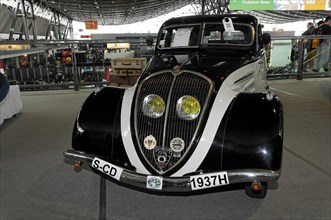 An elegant black vintage car from 1937 with chrome details and yellow headlights, Stuttgart Messe,