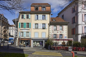 Historic, pastel-coloured houses with white windows and wooden shutters and the Cafe Vieil Ouchy in