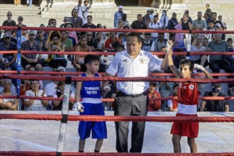 Oaxaca, Mexico, The referee declares the winner in a youth boxing match in the zocalo, Central