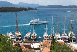 The view of a tranquil harbour with numerous sailing boats and yachts, surrounded by hills and