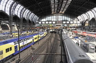 View over platforms with trains and passengers in a large station concourse, Hamburg, Hanseatic