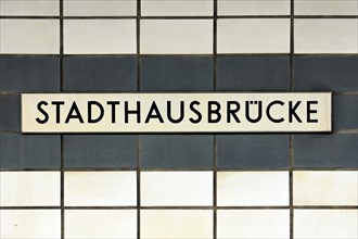 A sign with the inscription Stadthausbruecke on a wall with blue tiles, Hamburg, Hanseatic City of