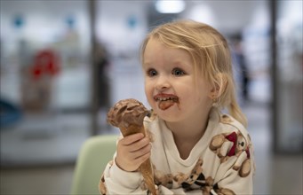 Interior shot, girl, 2-3 years, blonde, eating chocolate ice cream, ice cream, waffle, mouth