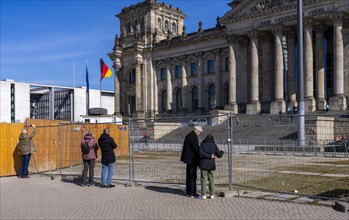 Tourists standing at the construction fence in front of the Reichstag building, Berlin, Germany,