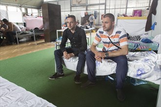 Refugees are housed in a gymnasium at the central contact point for asylum seekers in the state of
