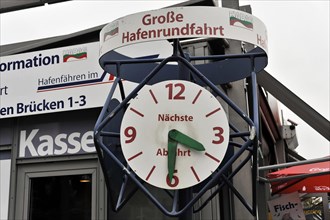 A large clock shows the time for the next harbour tour, surrounded by information, Hamburg,
