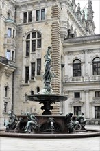 Opulent fountain with sculptures in front of historic architecture in a city centre, Hamburg,