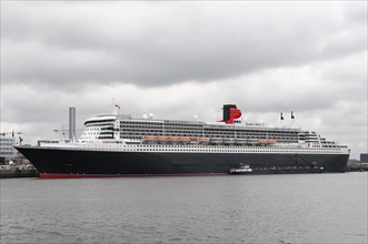 Side view of a large Cunard cruise ship Queen Mary 2, on a cloudy day, Hamburg, Hanseatic City of
