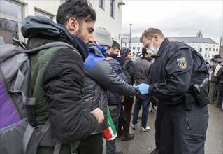 After arriving at Rosenheim station, refugees are given wristbands by federal police officers for