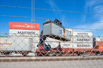 Lifting crane loading containers onto railways wagons in a dry port