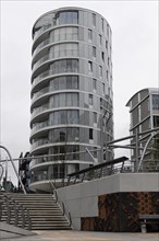 Round, modern glass building next to a staircase on a cloudy day, Hamburg, Hanseatic City of