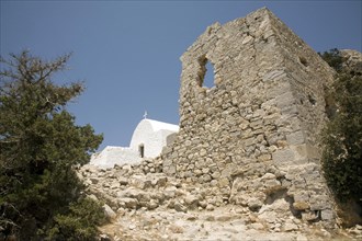 Castle walls and whitewashed Greek orthodox church, Kastrou Monolithos, Rhodes, Greece, Europe