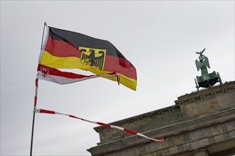 A waving German flag and Brandenburg flag with fluttering tape, the Brandenburg Gate in the