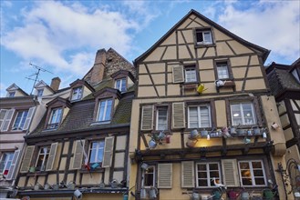 Facades of historic half-timbered houses decorated with watering cans in the old town centre of