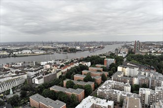 View of a city on a cloudy day with river and harbour facilities in the background, Hamburg,