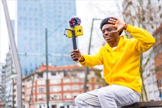 Side view photo with copy space of a young african content creator waving at camera recording a